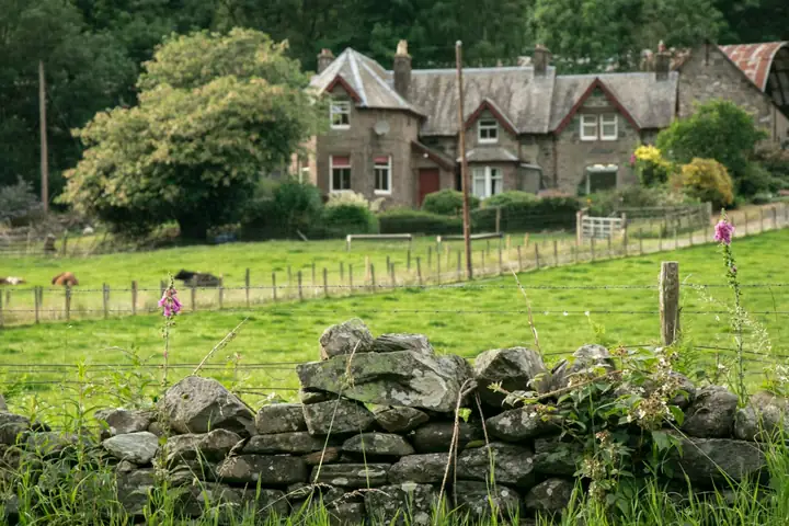 Stone farmhouse behind a dry stone wall