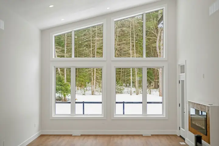 Bright room with tall windows looking onto trees